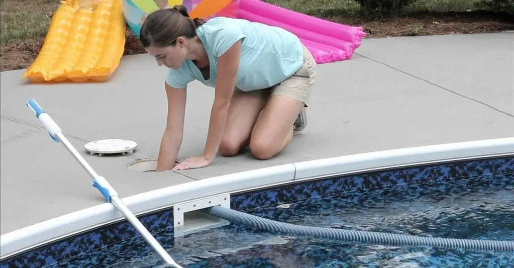 vacuuming above ground pool with sand filter